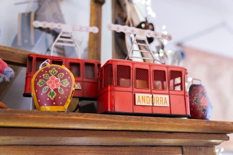 Telecabines vermelles en miniatura amb el rètol Andorra i esquelles pintades, a la botiga Grün Casa i Regals