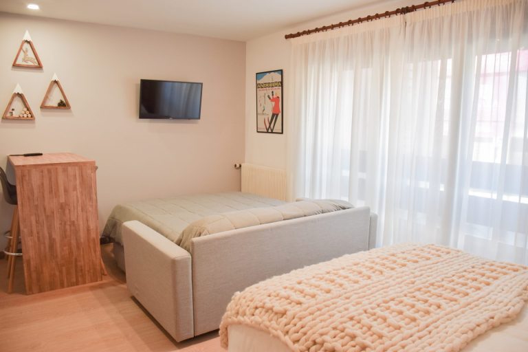 Zona del sofà llit doble al costat del llit a l'apartament ROC de Grün Estudis, Pas de la Casa