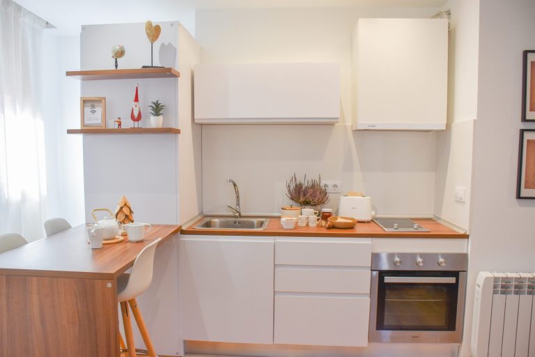 Cuina blanca equipada amb forn i prestatges de fusta a l'apartament SKY de Grün Estudis, Pas de la Casa