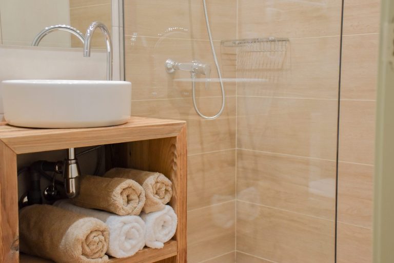 Bany amb lavabo de fusta i tovalloles enrotllades a l'apartament WOODY de Grün Estudis, Pas de la Casa